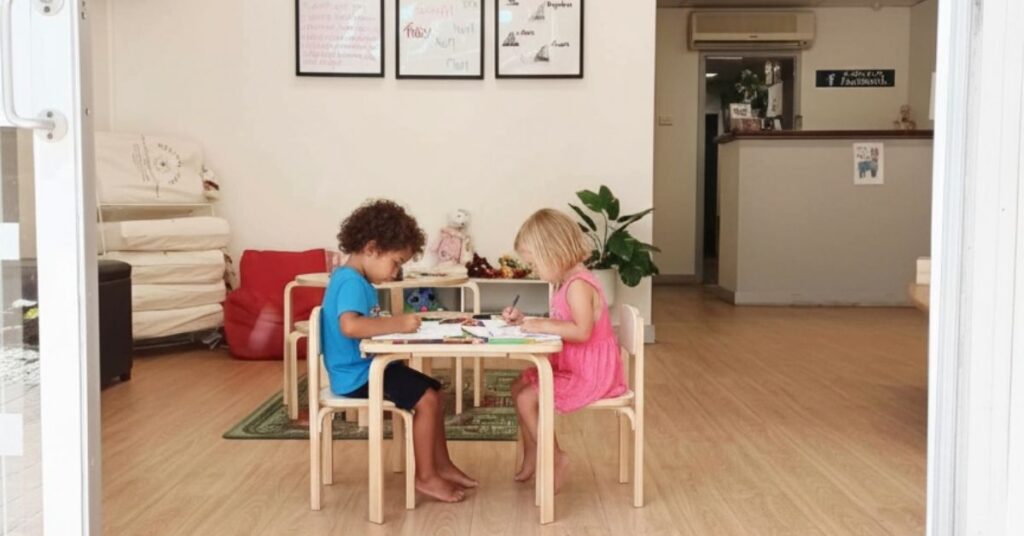 A child looking down at a table at the bundaberg clinic showing ‘tech neck’ posture.