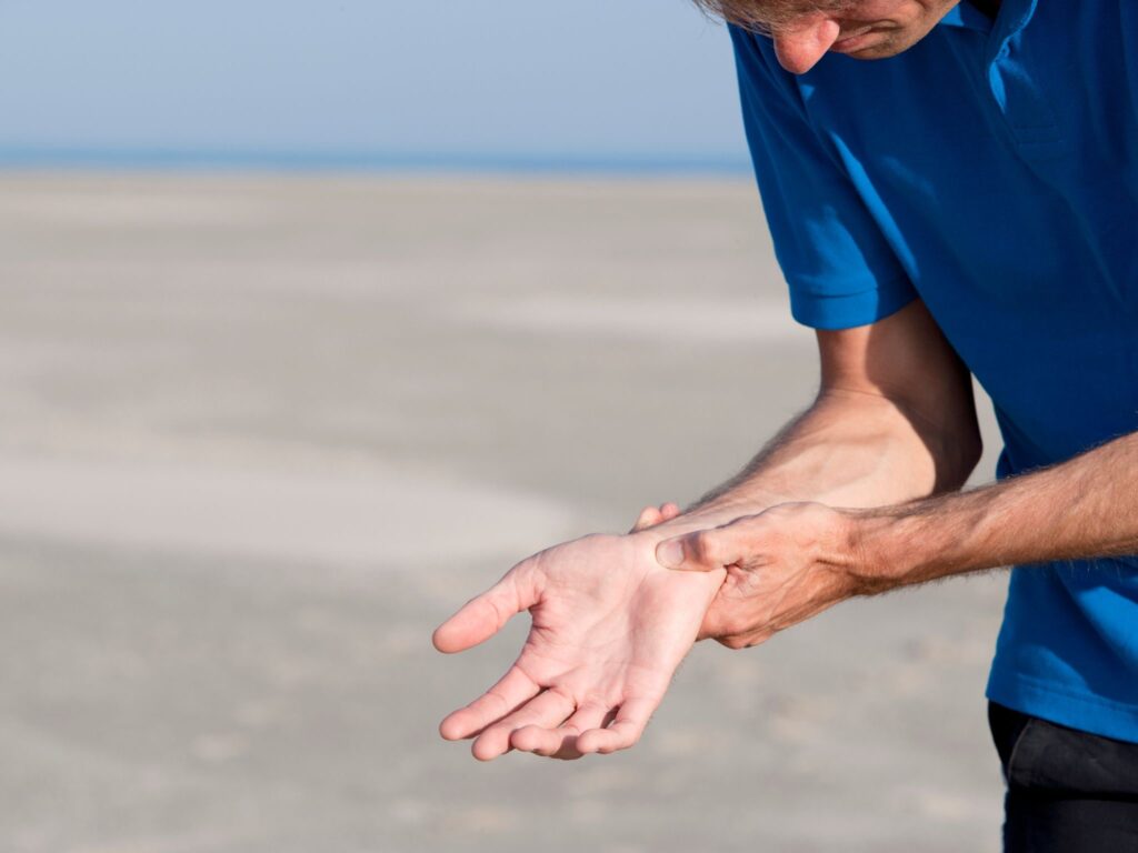 A man exercising holding his wrist in pain.