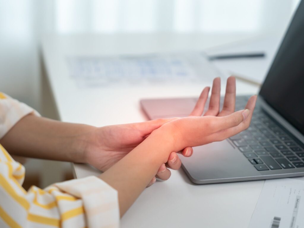 A female office worker holding her carpal tunnel area